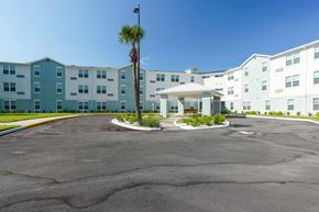Orlando apartment for rent - A palm tree stands in front of a white and blue building.