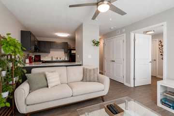 Orlando apartment for rent - A living room with a beige couch and a ceiling fan.