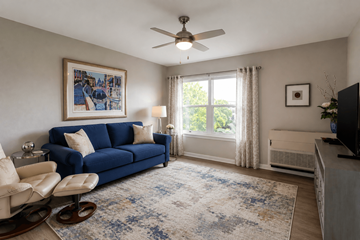 Fort Myers apartment for rent - A living room with a blue couch and a fan.