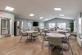 Fort Myers apartment for rent - A spacious room with tables and chairs and a television.