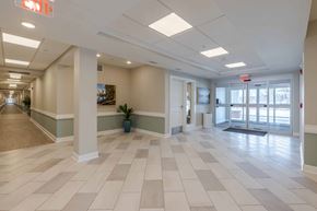 Kalamazoo apartment for rent - A long hallway with a tile floor and white pillars.