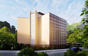Atlanta apartment for rent - A modern building with a glass facade is surrounded by greenery and a black fence.
