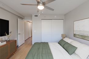 Atlanta apartment for rent - A bedroom with a bed, a ceiling fan, and a painting on the wall.