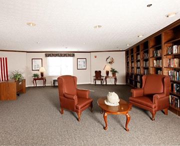 Whitehall apartment for rent - A living room with a carpeted floor and a bookshelf filled with books.