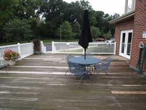 Fort Wayne apartment for rent - A patio with a table and chairs and a black umbrella.