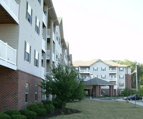 Fort Wayne apartment for rent - A large apartment complex with a brick building and a white building with balconies.