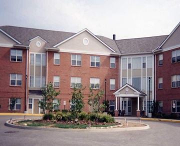 Wilkinsburg apartment for rent - A large red brick building with a landscaped front yard.