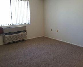 Glendale apartment for rent - A room with a carpeted floor and a window with blinds.