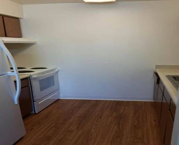Glendale apartment for rent - A kitchen with a white fridge, stove and oven, and a wooden floor.