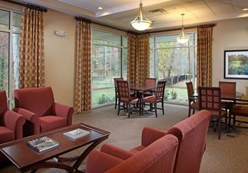 Atlanta apartment for rent - A living room with red chairs and a wooden coffee table.