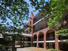 Savannah apartment for rent - A red brick building with a tower and balconies.