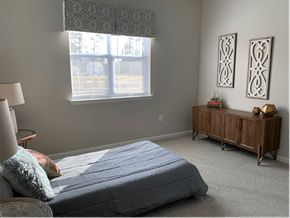 Pembroke apartment for rent - A bedroom with a bed, nightstand, and window.