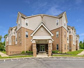 Middletown apartment for rent - A large, multi-story building with a brick facade and a covered entrance.