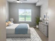 Columbus apartment for rent - A bedroom with a bed, dresser, and window overlooking a green area.