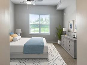 Columbus apartment for rent - A bedroom with a bed, dresser, and window overlooking a green area.