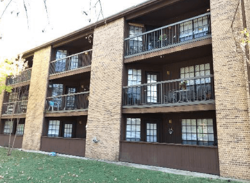 Waco apartment for rent - A brown building with a balcony on the second floor.