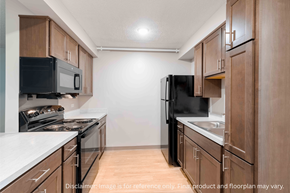 Atlanta apartment for rent - A kitchen with black appliances and wooden cabinets.