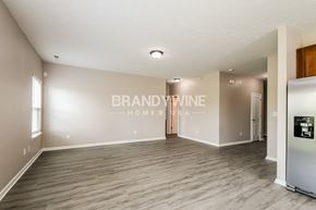 Sheridan house for rent - a living room with wood floors and a refrigerator
