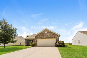 Sheridan house for rent - a house with a garage door and a lawn