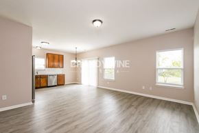 Sheridan house for rent - an empty living room with wood floors and a kitchen