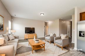 Sheridan house for rent - A living room with a wooden coffee table and grey couches.