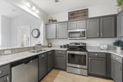 Virginia Beach apartment for rent - A kitchen with dark cabinets and stainless steel appliances at Saltmeadow Bay, Virginia Beach, VA, 23451
