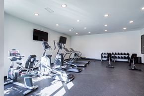 Chattanooga apartment for rent - A gym with a variety of exercise equipment including treadmills, stationary bikes, and weight racks.