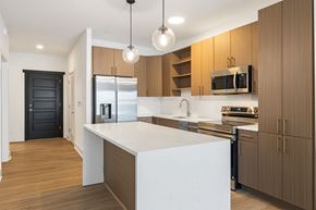 Asheville apartment for rent - A modern kitchen with wooden cabinets and a white island.