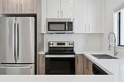 Miami Gardens apartment for rent - A modern kitchen with a stainless steel refrigerator, microwave, oven, and sink.at The Villages at Miami Gardens, Miami Gardens