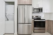 Miami Gardens apartment for rent - A modern kitchen with a stainless steel refrigerator, oven, and microwave.at The Villages at Miami Gardens, Miami Gardens, FL