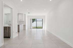 Miami Gardens apartment for rent - A spacious, empty room with white walls and tile flooring.at The Villages at Miami Gardens, Miami Gardens Florida