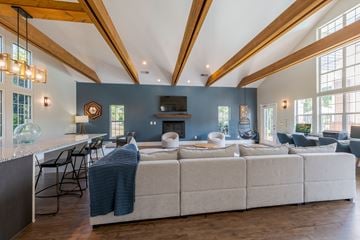 Greensboro apartment for rent - A large sectional sofa with a blanket on it sits in a spacious living room.