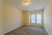 Greensboro apartment for rent - A room with a carpeted floor and a window with a view of trees.