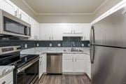 Greensboro apartment for rent - A modern kitchen with white cabinets and stainless steel appliances.