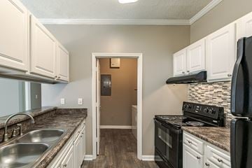 Macon apartment for rent - A kitchen with a black stove top oven and white cabinets.