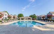 Warner Robins apartment for rent - A large swimming pool surrounded by lounge chairs and umbrellas.