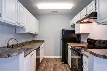 Augusta apartment for rent - A kitchen with black appliances and white cabinets.