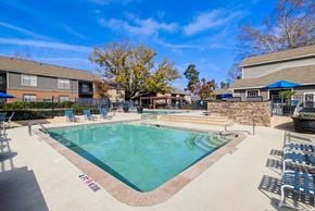 Augusta apartment for rent - A pool surrounded by chairs and trees.