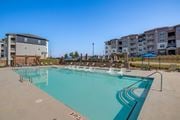 Commerce apartment for rent - A large swimming pool with lounge chairs and apartment buildings in the background.