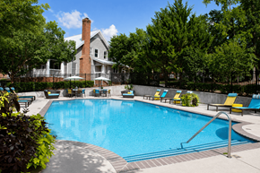Martinez apartment for rent - A large swimming pool surrounded by trees and chairs.