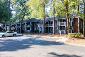 Aiken apartment for rent - A white car is parked on the street in front of apartment buildings.