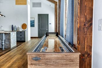 A shuffleboard table in the middle of a living room