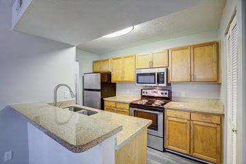 Athens apartment for rent - A kitchen with wooden cabinets and a granite countertop.