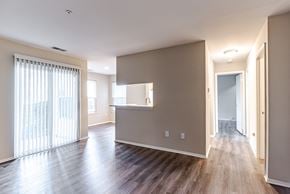Midlothian apartment for rent - A spacious room with wooden floors and a large window with white curtains.