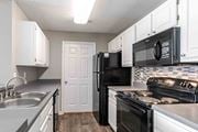 Warner Robins apartment for rent - A kitchen with black appliances and white cabinets.