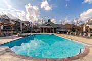 Warner Robins apartment for rent - A large swimming pool in the middle of a resort surrounded by chairs.