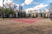 Warner Robins apartment for rent - A tennis court is surrounded by apartment buildings.