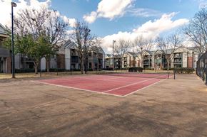 Warner Robins apartment for rent - A tennis court is surrounded by apartment buildings.