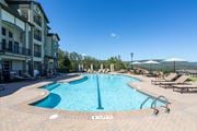 Hixson apartment for rent - A large outdoor swimming pool surrounded by a brick patio and lounge chairs.