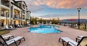 Hixson apartment for rent - a swimming pool with chairs and umbrellas next to a building at Integra Vista Apartments, Hixson, TN